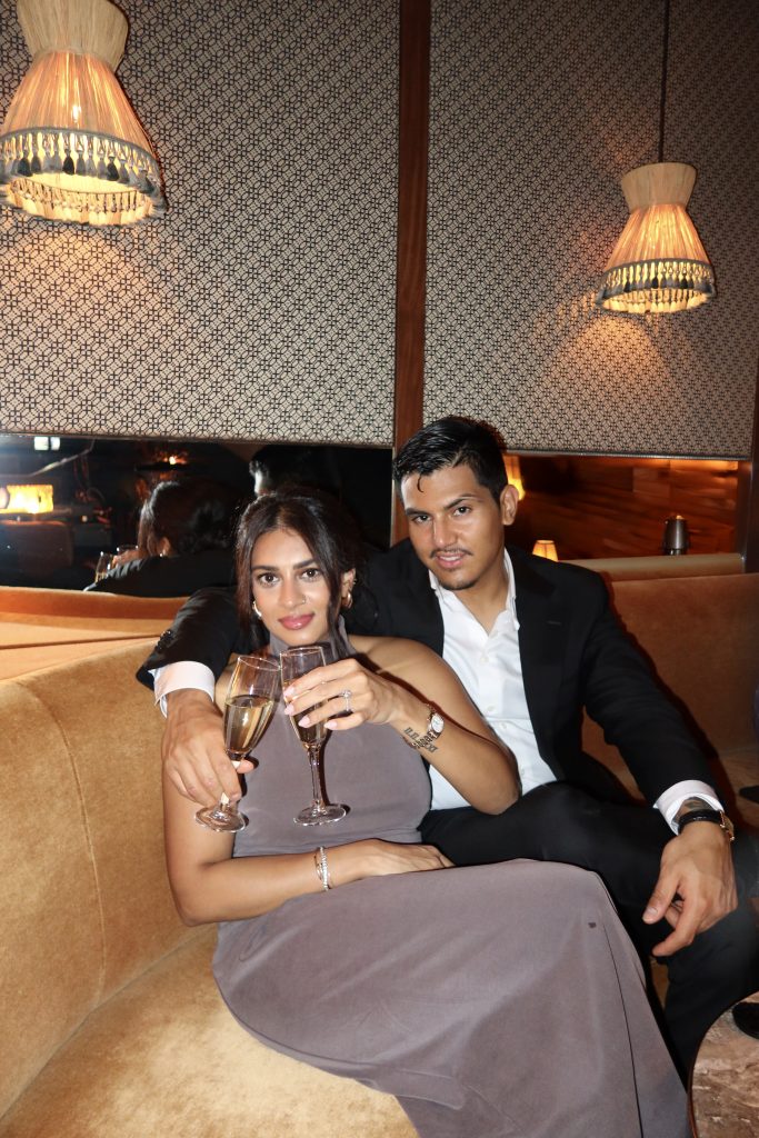 Dipali and Edgar seated together at a candlelit lounge