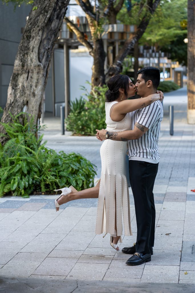 Dipali and Edgar embracing on a tree-lined street